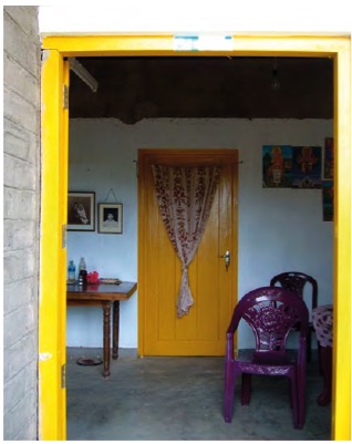 Doorway to a room, where the door frame is painted yellow